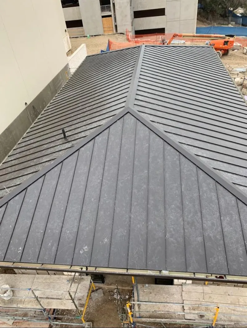 Commercial metal roof construction with crane equipment in Maryland City